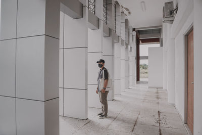 Full length of young man standing against building