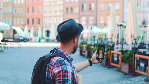 Portrait of man using mobile phone in city