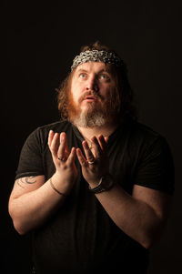 Portrait of man wearing mask against black background