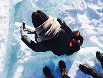 High angle view of person photographing while standing on snow covered field