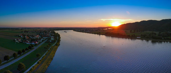 Scenic view of river against sky during sunset