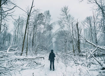 Rear view of man standing on snow covered field