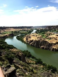 Scenic view of river by landscape against sky