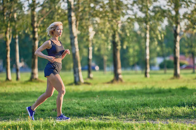 Full length of woman running on grass