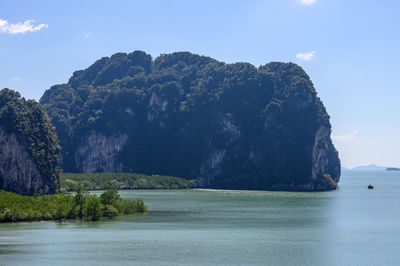 Rock formation in sea against sky