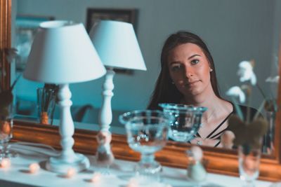 Close-up portrait of young woman sitting on table