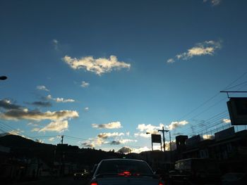 Cars on road in city against sky