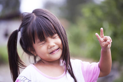 Cute girl making face while standing outdoors