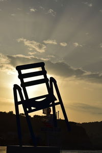 Silhouette metallic structure against sky during sunset