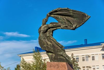 Low angle view of statue against blue sky