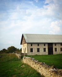 Old house on field against sky