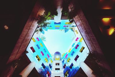 Low angle view of illuminated lanterns hanging amidst buildings at night
