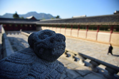 Close-up of animal sculpture by building against clear sky