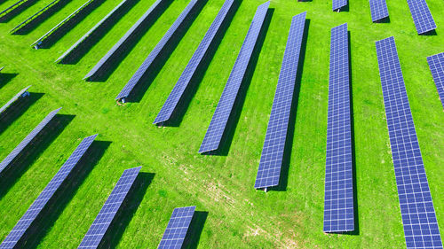 Solar panels in green field, aerial view