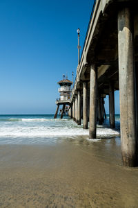 Pier on beach against clear sky