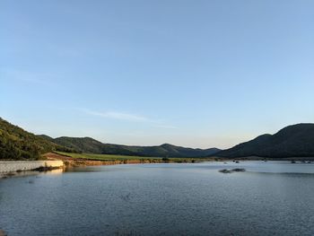 Scenic view of lake against clear blue sky