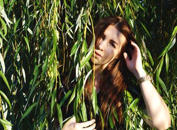 Portrait of young woman against plants