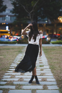 Full length of woman walking on footpath in city