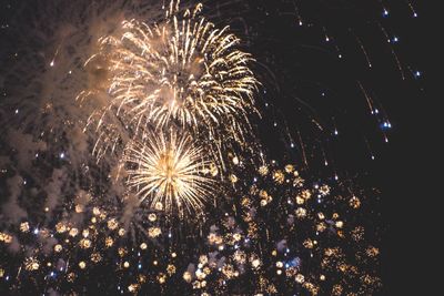 Low angle view of firework display at night