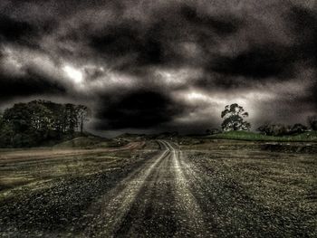 Road by storm clouds over landscape