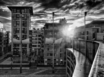 Buildings in city against cloudy sky