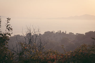 Distant view o an estate in the mountains of tuscany against sky during foggy weather