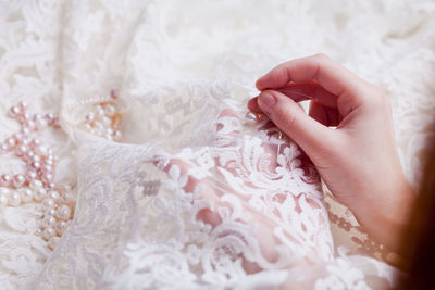 Cropped hands of woman stitching wedding dress