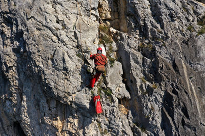 Aerial view of mountain rescuer doing rescue operations hanging on a rope