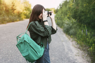 Cute brunette looks at the camera lens. a girl photographs nature. 