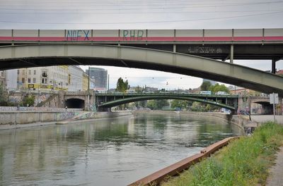 Bridge over river in city against sky