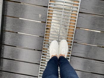 Low section of person standing on metal floor