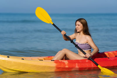 Young woman kayaking in sea