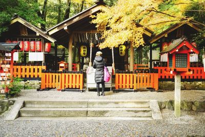 Rear view of woman standing at temple