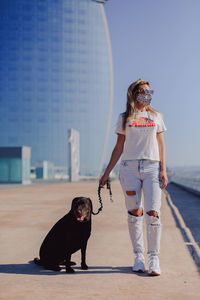 Woman with dog against sky