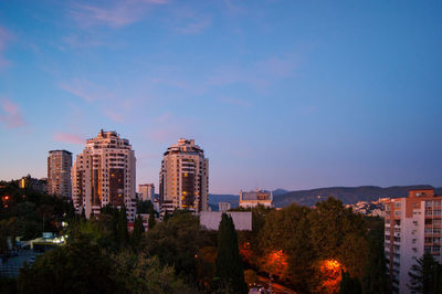 Buildings in city against blue sky