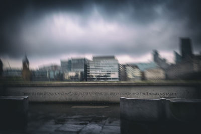 Buildings by river against sky