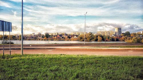 Scenic view of field by buildings against sky