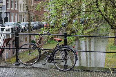 Bicycle on footpath by river in city