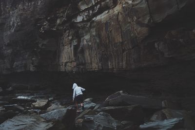 Rear view of person standing in cave