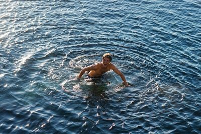 High angle view of shirtless man swimming in sea