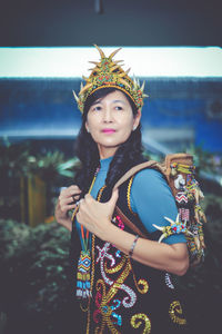 Portrait of young woman standing against sky