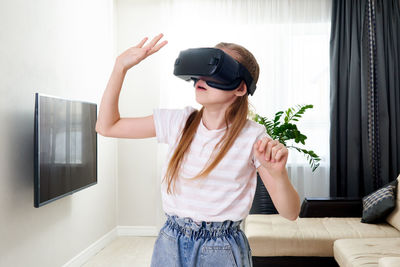 Girl wearing virtual reality simulator at home