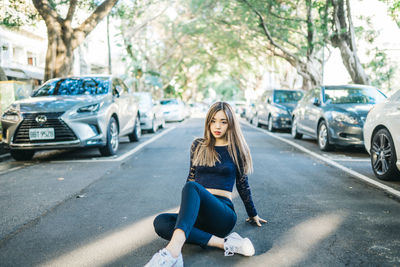 Full length of woman sitting on road