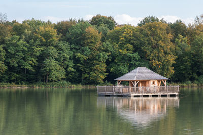 Gazebo by lake against trees in forest