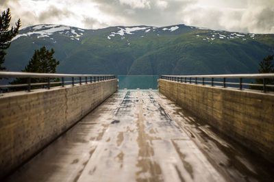 Footbridge leading towards mountains during winter