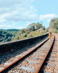 Railroad tracks by trees against sky