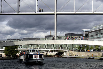 Bridge over river against sky in city