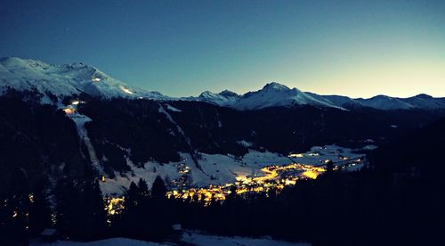 Scenic view of snow covered mountains against clear sky at dusk