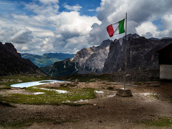 Scenic view of mountains against sky and italian flag