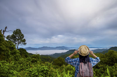 Woman standing by plants against sky